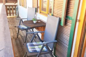 twee stoelen en een tafel op een veranda met een tafel bij Ferienwohnung im Gästehaus Sieger-Brandner in Ramsau