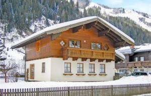 a wooden house with a balcony in the snow at Große Ferienwohnung Grossarl in Grossarl