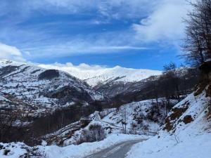 una montaña cubierta de nieve con una carretera en primer plano en Vejtse House 