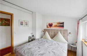 um quarto branco com uma cama com lençóis brancos em Stunning Apartment In Hergatz With House A Panoramic View em Hergatz