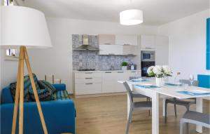 una cucina e una sala da pranzo con tavolo e divano blu di 2 Bedroom Gorgeous Apartment In Sciacca Ag a Sciacca