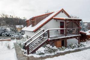 a house with a snow covered roof and stairs at Pod Vojtěchem - soukromý wellness apartmán in Wotitz