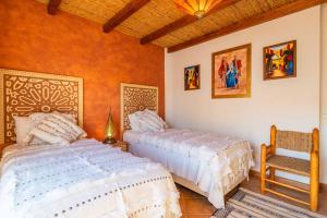 a bedroom with two beds and a chair in it at Villa Oasis Galé - Luxury Villa with private pool, AC, free wifi, 5 min from the beach in Albufeira +35 photos
