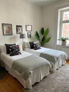 two beds in a white room with at Stockholm Loft Haven 3 Beds in a 1- Bedroom Gem - 917 in Stockholm