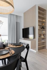 a dining room with a table and a tv at Apartament Redłowska Kępa nad Morzem in Gdynia