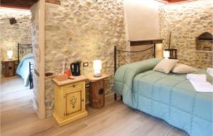um quarto com uma cama e uma parede de pedra em 2 Bedroom Nice Apartment In Castel Ritaldi em Castel Ritaldi