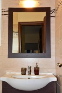La salle de bains est pourvue d'un lavabo et d'un miroir. dans l'établissement Andros Country Residence, à Makrotándalon
