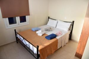 ein Bett mit Handtüchern und Kissen darauf in einem Zimmer in der Unterkunft Andros Country Residence in Makrotándalon