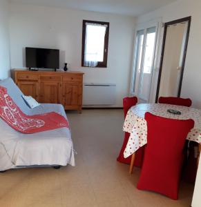 salon ze stołem i czerwonymi krzesłami w obiekcie appt 2 ou 4 personnes avec piscine, tennis et parking privé w mieście Fleury