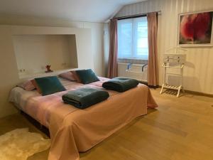 Un dormitorio con una cama grande con almohadas verdes. en Vakantiewoning Het Wielje Maasland, en Kinrooi