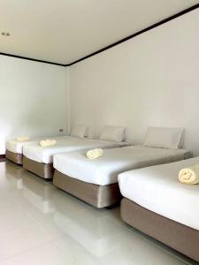 três camas num quarto com paredes brancas em Ozone Chomdao Resort em Wang Nam Khieo
