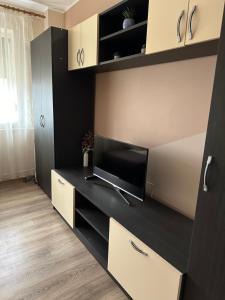 a living room with a tv on a desk at Cozy Apartament in Galaţi