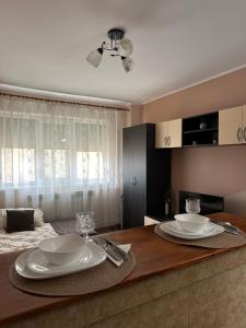 a dining room table with plates on top of it at Cozy Apartament in Galaţi