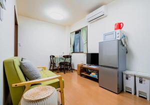- un salon avec un réfrigérateur et un canapé dans l'établissement Kaya no Kochiku, à Kyoto