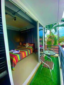 a balcony with a bed and a table on a balcony at Chatchada House in Ao Nang Beach