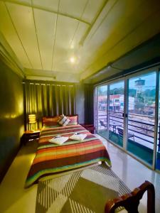 a bedroom with a bed and a large window at Chatchada House in Ao Nang Beach