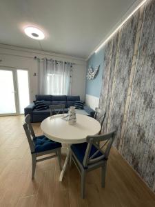 een woonkamer met een tafel en stoelen en een bank bij Domek v srdci Fara in Faro