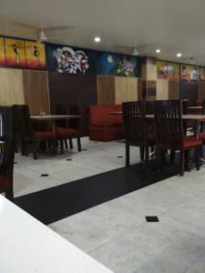 a dining room with wooden chairs and tables in a restaurant at Hotel Shelter Inn,Chhatarpur in Chhatarpur