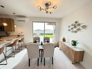 cocina y comedor con mesa y sillas en New 4 Bedroom Home with Ocean and Gorgeous Mountain Views in the gated community of Mauna Olu, en Waianae