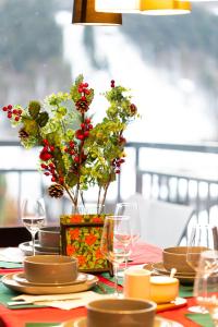 a table with plates and glasses and a vase with flowers at Szczyrkowskie SKI & FUN 16 - z widokiem na góry in Szczyrk