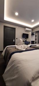 a hotel room with two beds with white sheets at SAND DOOR HOTEL in Istanbul
