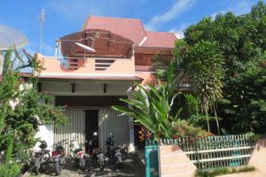 une maison avec des motos garées devant elle dans l'établissement Nola's Homestay, à Kampungdurian