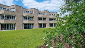 un edificio de apartamentos con un césped verde delante de él en Park-Apartment Scharmützelsee Wohnung 1, en Wendisch Rietz