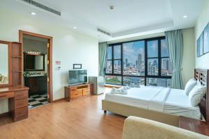 a bedroom with a large bed and a large window at ANINA Office & Serviced Apartments in Phnom Penh