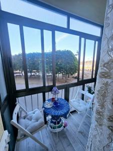 een kamer met een tafel, 2 stoelen en een raam bij Sweet home in Barcelona