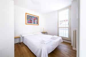 een witte slaapkamer met een groot bed en een raam bij Loft Porta Maggiore in Rome