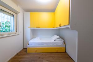een kleine slaapkamer met gele kasten en een bed bij Loft Porta Maggiore in Rome