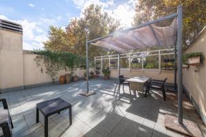 een terras met een tafel en stoelen onder een pergola bij Loft Porta Maggiore in Rome