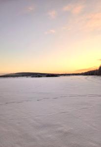 - une vue sur un lac gelé au coucher du soleil dans l'établissement Aron Hill Home, à Rovaniemi