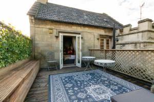 a patio with a table and a rug on a balcony at The Northey Arms in Box