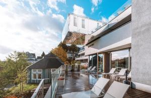 a balcony of a house with white chairs at DIEDRICH Wellnesshotel & SPA - Adults only in Hallenberg