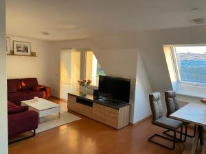 a living room with a couch and a television at Sonnige Wohnung mit Balkon in Eppingen