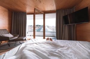 1 dormitorio con 1 cama, TV y sofá en DIEDRICH Wellnesshotel & SPA - Adults only, en Hallenberg