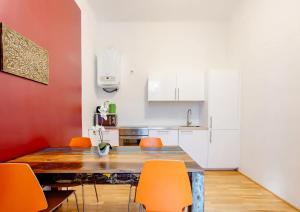 kuchnia z drewnianym stołem i pomarańczowymi krzesłami w obiekcie Exclusive Apartment City Center w Wiedniu