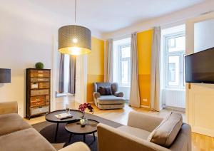 a living room with a couch and a tv at Exclusive Apartment City Center in Vienna