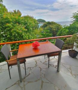 a table on a balcony with a view of the ocean at Lonos Circle Ocean View Room in Romblon