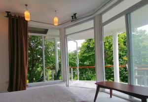 een slaapkamer met een bed en een groot raam bij Lonos Circle Ocean View Room in Romblon