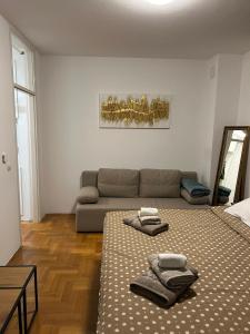 salon z 2 łóżkami i kanapą w obiekcie Apartment Lenbonne w Zagrzebiu