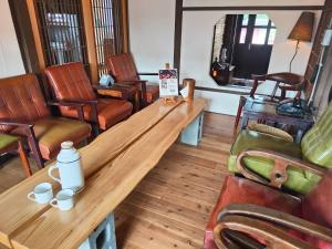 a room with chairs and a wooden table with cups on it at Soho工房眷村生活體驗館 in Kaohsiung