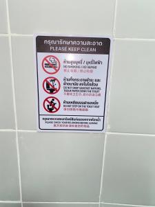 un cartel en una pared de azulejos en un baño en Guesthouse Station, en Bangkok