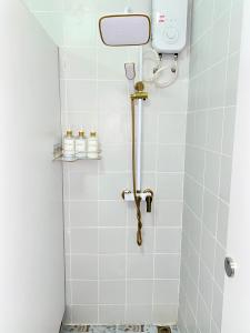 Un baño con ducha con azulejos blancos. en Guesthouse Station, en Bangkok