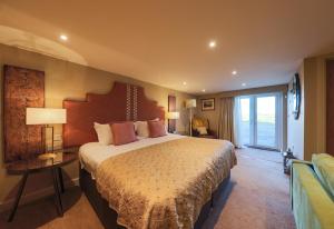 a bedroom with a large bed in a room at The Pheasant Pub at Gestingthorpe Stylish Boutique Rooms in The Coach House in Gestingthorpe