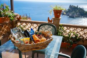 a basket of food on a table with a view of the ocean at Mendolia Beach Hotel in Taormina