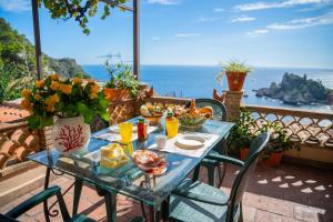a table with food on a balcony with a view of the ocean at Mendolia Beach Hotel in Taormina