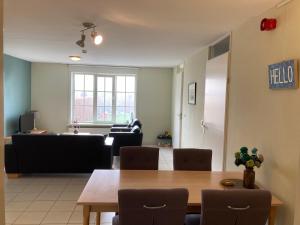 een eetkamer en een woonkamer met een tafel en stoelen bij Accommodatie in herbouwde boerenschuur K in Retranchement