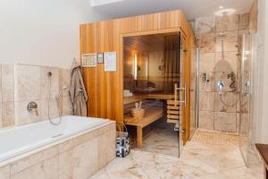 a large bathroom with a tub and a shower at Hotel Villa Toskana in Leimen